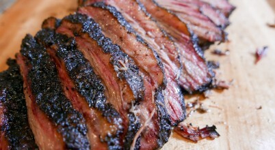 Sliced smoked brisket beef on a wooden cutting board