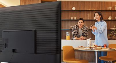 Samsung's 2025 TV range includes the Crystal lineup, with 43 inch, 50 inch, 55 inch, 65 inch, 75 inch and 85 inch 4K UHD screens to choose from. TV is pictured from rear with woman and man watching it.